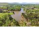 Picturesque aerial view of the lake surrounded by green trees and residences in a serene setting at 6165 Lake Oak Lndg, Cumming, GA 30040