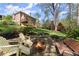 Inviting backyard features a fire pit area with Adirondack chairs, a spacious lawn, and mature trees at 6165 Lake Oak Lndg, Cumming, GA 30040