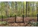 Gated backyard access with a wooded view offering both security and natural beauty at 6165 Lake Oak Lndg, Cumming, GA 30040