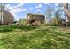 Spacious backyard featuring a lush lawn, garden beds, and multi-level deck and patio areas at 6165 Lake Oak Lndg, Cumming, GA 30040