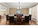 Formal dining room with elegant chandelier, wainscoting, and large window dressed with light curtains at 6165 Lake Oak Lndg, Cumming, GA 30040