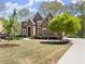 Beautiful brick home with manicured lawn, mature trees, and a circular driveway at 6165 Lake Oak Lndg, Cumming, GA 30040