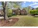 Charming brick home with lush green lawn, mature landscaping, and a welcoming facade at 6165 Lake Oak Lndg, Cumming, GA 30040
