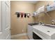 Functional laundry room with a washer, dryer, and shelving for storage, making laundry tasks a breeze at 6165 Lake Oak Lndg, Cumming, GA 30040