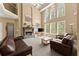 Bright living room with soaring ceilings, a fireplace, large windows, and comfortable seating at 6165 Lake Oak Lndg, Cumming, GA 30040