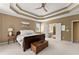 Spacious main bedroom featuring a tray ceiling, neutral walls, and a large bed with a wooden chest at its foot at 6165 Lake Oak Lndg, Cumming, GA 30040