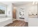 Bright bathroom featuring tub, walk-in shower and vanity, with an open view of the bedroom at 11841 Rizvan Pl, Covington, GA 30014