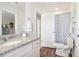 Bathroom features a granite vanity, wood-look flooring, and a toilet with patterned shower curtain at 11841 Rizvan Pl, Covington, GA 30014