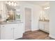 Bright bathroom offers dual sinks, white cabinets, and wood-look flooring at 11841 Rizvan Pl, Covington, GA 30014