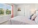 Bright bedroom features a large window with natural light, carpet flooring, and a cozy quilted bedspread at 11841 Rizvan Pl, Covington, GA 30014