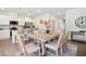 Open dining area with light wood table and seating, and an adjacent kitchen featuring stainless steel appliances at 11841 Rizvan Pl, Covington, GA 30014