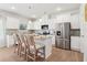 Well-lit kitchen with white cabinetry, granite countertops, stainless steel appliances and seating at the island at 11841 Rizvan Pl, Covington, GA 30014