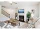 Comfortable living room with fireplace, staircase, and neutral color palette at 11841 Rizvan Pl, Covington, GA 30014