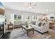 Sunlit living room featuring stylish furniture, a fireplace, and views of the backyard at 11841 Rizvan Pl, Covington, GA 30014