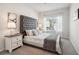 Cozy main bedroom featuring a tufted headboard, decorative pillows, and a window with natural light at 11841 Rizvan Pl, Covington, GA 30014