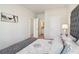 Cozy main bedroom featuring a tufted headboard, soft linens, and a view into the ensuite bathroom at 11841 Rizvan Pl, Covington, GA 30014