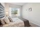 Inviting main bedroom with a plush bed, neutral tones, and a window offering views of the neighborhood at 11841 Rizvan Pl, Covington, GA 30014