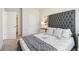 Serene main bedroom with tufted headboard, soft linens, and an ensuite bathroom entrance at 11841 Rizvan Pl, Covington, GA 30014