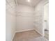 Spacious walk-in closet with ample shelving and carpeted flooring, perfect for organization at 11841 Rizvan Pl, Covington, GA 30014