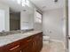 Bathroom featuring a granite countertop, large mirror, wood cabinets, neutral paint, and tile flooring at 1342 Rietveld Nw Row, Atlanta, GA 30318