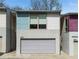 Exterior of modern townhome featuring a gray garage door and colorful facade with windows at 1342 Rietveld Nw Row, Atlanta, GA 30318