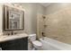 Tiled bathroom featuring a dark vanity, toilet, and tub with shower head at 3405 Camellia Ln, Suwanee, GA 30024