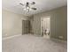 Neutral bedroom with ceiling fan, carpet, and two doors leading to other rooms at 3405 Camellia Ln, Suwanee, GA 30024