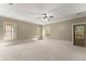 Spacious bedroom featuring plush carpeting, a ceiling fan, and abundant natural light from multiple windows at 3405 Camellia Ln, Suwanee, GA 30024