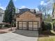 Attractive brick home with a two-car garage, well-kept lawn, and mature trees at 3405 Camellia Ln, Suwanee, GA 30024