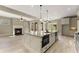 Bright kitchen with an island, stainless appliances, and an adjacent sitting room with a fireplace at 3405 Camellia Ln, Suwanee, GA 30024