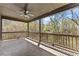 Covered porch with tile flooring, railing, and a view of the wooded backyard at 3405 Camellia Ln, Suwanee, GA 30024