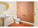 Half bathroom features hardwood floors, pedestal sink with a mirror, and a toilet at 907 Hindman Pl, Mcdonough, GA 30253