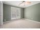 Cozy bedroom with neutral carpet, ceiling fan, and a bright window at 907 Hindman Pl, Mcdonough, GA 30253
