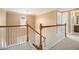 Upstairs hallway features a wooden and white banister, with access to bedrooms and bathrooms at 907 Hindman Pl, Mcdonough, GA 30253