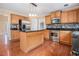 Modern kitchen with wood cabinets, stainless steel appliances, granite countertops, and island at 907 Hindman Pl, Mcdonough, GA 30253