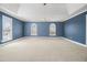 Spacious bedroom features a ceiling fan, large windows, and neutral carpet at 907 Hindman Pl, Mcdonough, GA 30253