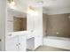 Bright bathroom with a double sink vanity, large mirror, and tiled bathtub at 3246 Wellington Sw Walk, Atlanta, GA 30331