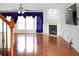 Bright living room with hardwood floors, a fireplace, and large windows with elegant drapes at 3246 Wellington Sw Walk, Atlanta, GA 30331