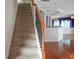 Carpeted stairs with wooden railing leading to an upper level, adjacent to the living space at 3246 Wellington Sw Walk, Atlanta, GA 30331