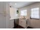 Bright kitchen with white cabinets, quartz countertops, stainless steel appliances, and view of the backyard through a white door at 4282 Roswell Ne Rd # G1, Atlanta, GA 30342