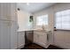 Bright kitchen with white cabinets, quartz countertops, stainless steel appliances, and view of the backyard through a white door at 4282 Roswell Ne Rd # G1, Atlanta, GA 30342