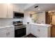 Bright modern kitchen with quartz countertops, stainless steel appliances, white cabinets and view of the wall-mounted display shelf at 4282 Roswell Ne Rd # G1, Atlanta, GA 30342