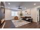 Inviting living room with dark wood floors, ceiling fan, large grey couch, orange chair and fireplace at 4282 Roswell Ne Rd # G1, Atlanta, GA 30342