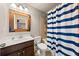 Cozy bathroom with blue striped shower curtain and rustic framed mirror at 4467 Sterling Pointe Nw Dr, Kennesaw, GA 30152