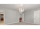 Bonus room featuring crystal chandelier and hallway leading to bath and stairs at 4467 Sterling Pointe Nw Dr, Kennesaw, GA 30152