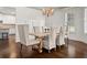 Formal dining room features wood floors, a decorative chandelier, and six upholstered chairs at 4467 Sterling Pointe Nw Dr, Kennesaw, GA 30152