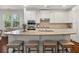 Kitchen island featuring granite countertop, seating, stainless steel sink, and ample cabinet space at 4467 Sterling Pointe Nw Dr, Kennesaw, GA 30152