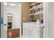 Functional laundry room with white washer and dryer, shelving, and stylish decor at 4467 Sterling Pointe Nw Dr, Kennesaw, GA 30152