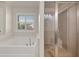 Bright bathroom featuring a soaking tub and glass shower with bench at 4467 Sterling Pointe Nw Dr, Kennesaw, GA 30152