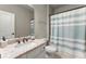 Well-lit bathroom with a granite countertop, white cabinetry, and a shower with a blue striped curtain at 226 Chastain Preserve Ne Ln, Atlanta, GA 30342